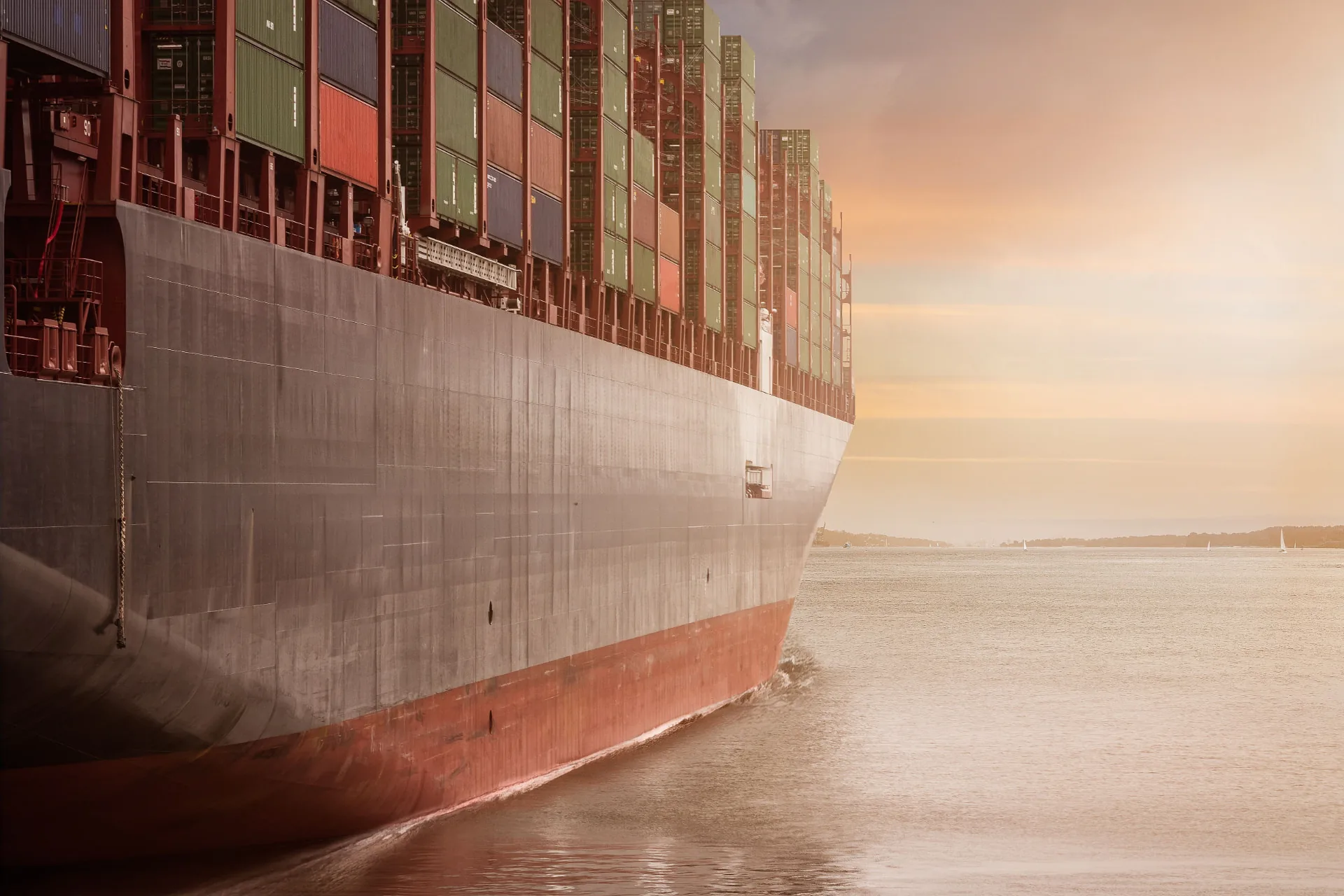 Loaded container ship sailing at sunset, symbolizing global wholesale trade